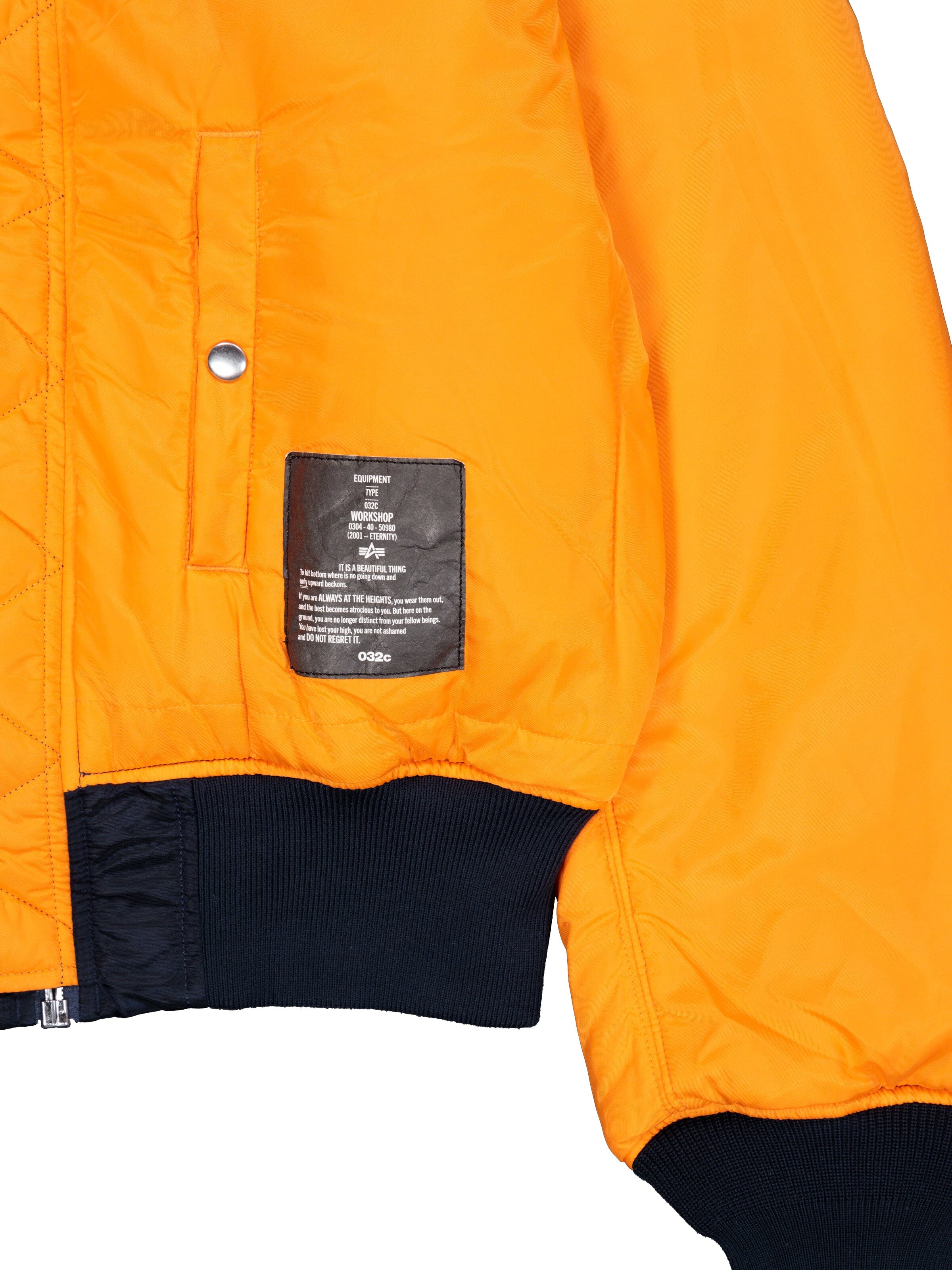 Alpha X 032C Flight Bomber by Alpha Industries, bright orange flight nylon, black ribbed cuffs and waistband, silver snap button, pocket, black label patch on front.