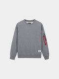 Alpha Industries Utility Pocket Crewneck in Medium Charcoal Heather with MA-1 utility pocket and red zip tag on left sleeve.