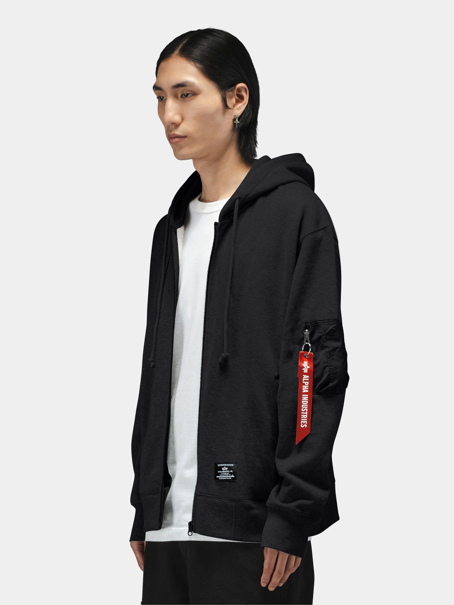 Alpha Industries Utility Pocket Full Zip Up, black hoodie with red tag on sleeve, layered over white t-shirt.