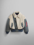 The Women's B-15 Sherpa Hybrid Bomber Jacket by Alpha Industries is a two-tone design in field gray with a beige fleece upper and dark green sleeves. It features eye-catching sherpa paneling, a large removable collar, front pockets, and a zippered sleeve pocket adorned with a red tag.