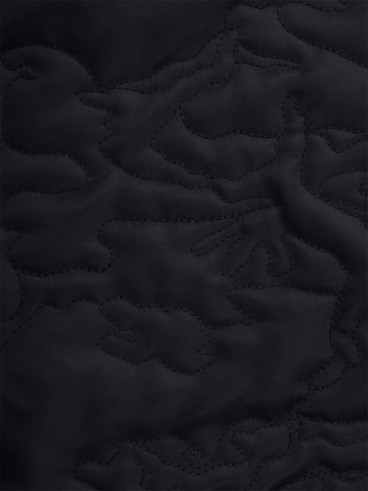 Close-up of the black quilted fabric from the Alpha Industries Women's Camo Quilted Belted MA-1 Bomber Jacket, featuring abstract stitching patterns.