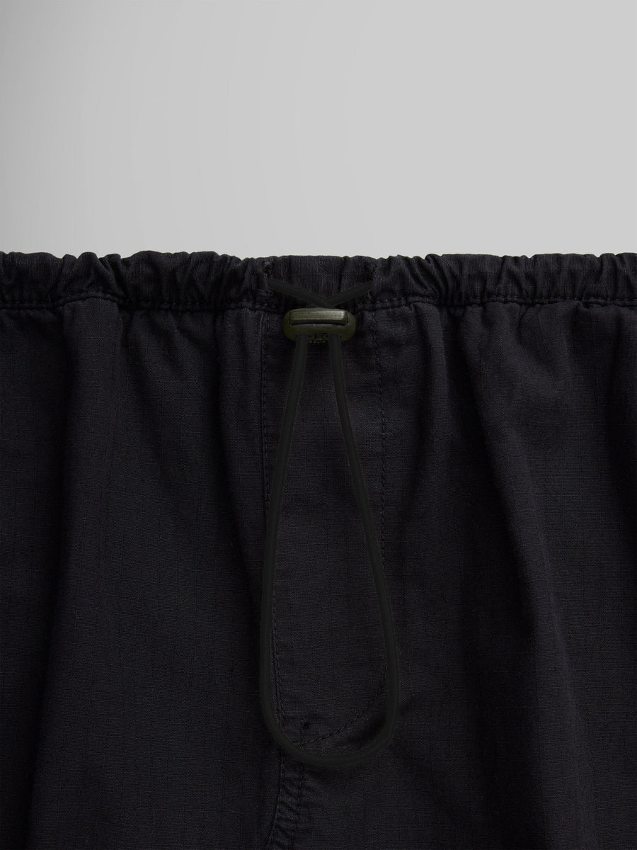 Close-up of the Women's Drawcord Skirt by Alpha Industries, showcasing its black fabric with a bungee waistband and drawstring tied in a loop.