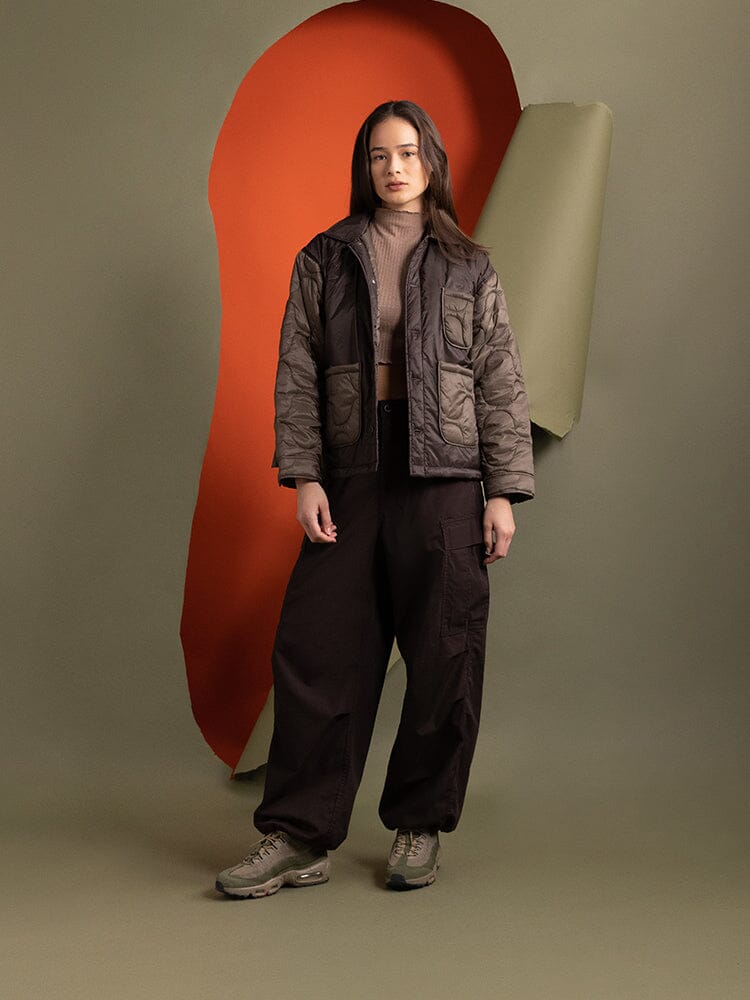 Full body view of a person wearing the Women's Insulated Chore Coat in chocolate from Alpha Industries.