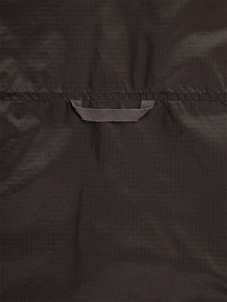Close-up back view of the Women's Insulated Chore Coat in chocolate by Alpha Industries, featuring a dark nylon ripstop fabric with a centrally located small stitched loop, reminiscent of onion quilting.