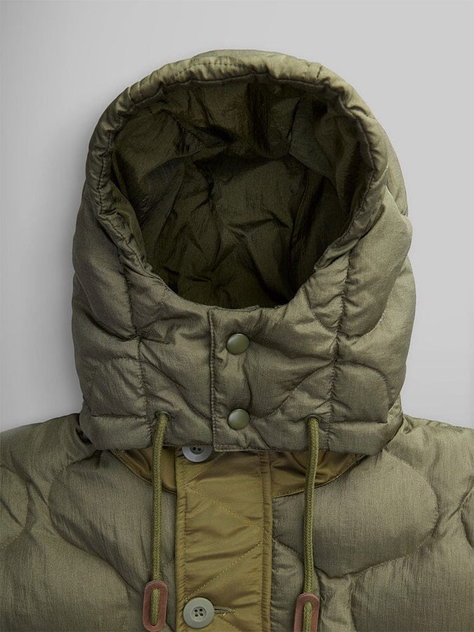 Close-up of the Women's M-65 Fishtail Puffer by Alpha Industries featuring an olive hooded design with onion quilting and button details on the front.
