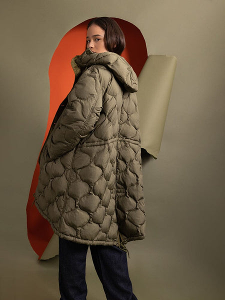 Back view of a person wearing the Women's M-65 Fishtail Puffer in quilted olive green, designed by Alpha Industries.