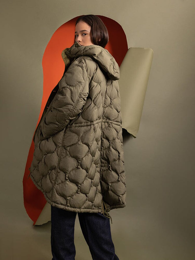 Back view of a person wearing the Women's M-65 Fishtail Puffer in quilted olive green, designed by Alpha Industries.