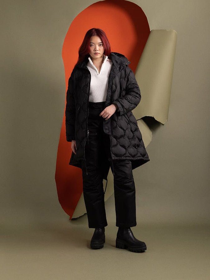 A person wearing the Women's M-65 Fishtail Puffer in black from Alpha Industries.