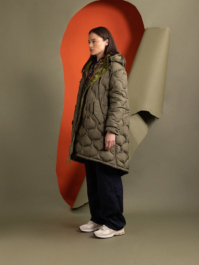 Side-view of a person wearing the Women's M-65 Fishtail Puffer in green from Alpha Industries.