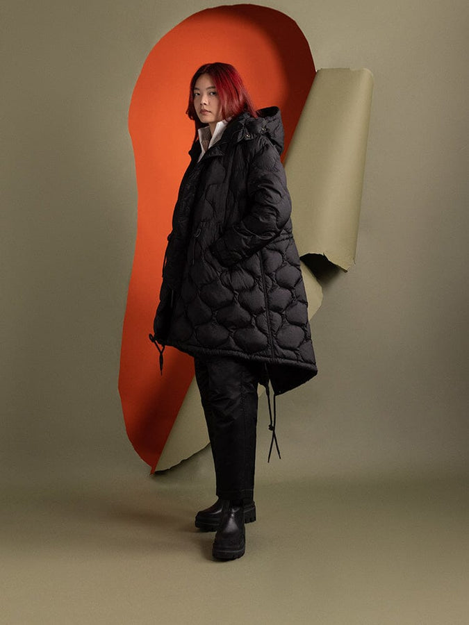 Side-view of a person wearing the Women's M-65 Fishtail Puffer in black by Alpha Industries.