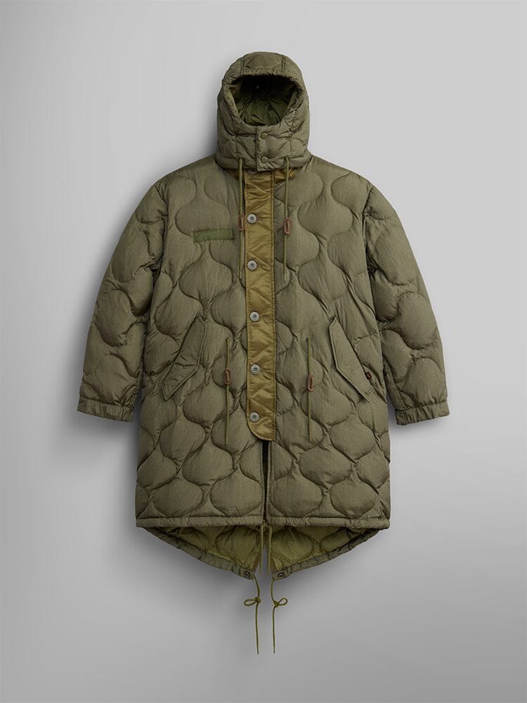 The Women's M-65 Fishtail Puffer by Alpha Industries in OG-107 Green, featuring a water-resistant fabric with onion quilting, a hood, button and zipper closure, an asymmetric hem, and adjustable drawstrings at the waist and hem.