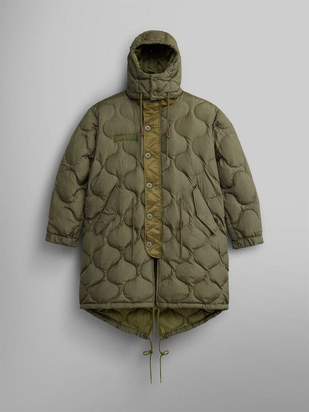The Women's M-65 Fishtail Puffer by Alpha Industries in OG-107 Green, featuring a water-resistant fabric with onion quilting, a hood, button and zipper closure, an asymmetric hem, and adjustable drawstrings at the waist and hem.