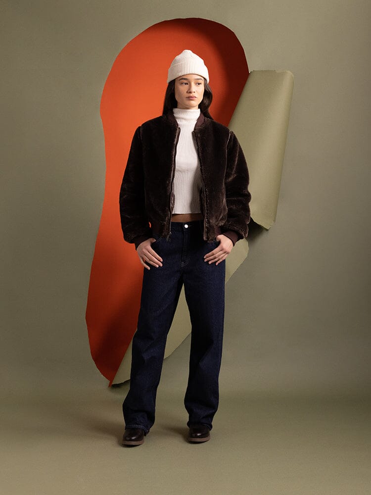A person wearing the reversible side of the Women's Reversible Faux Leather MA-1 Bomber Jacket in brown chocolate by Alpha Industries.