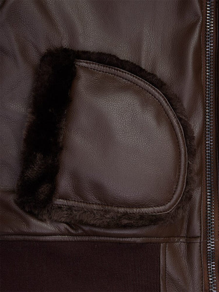 Close-up of the Women's Reversible Faux Leather MA-1 Bomber Jacket by Alpha Industries, featuring a brown faux leather material with a zipped pocket and dark shearling lining.