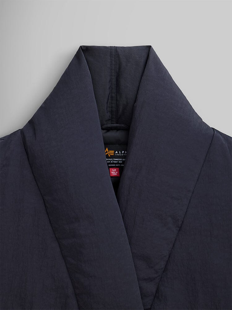 Close-up of the Women's Shawl Collar Bomber Jacket in black by Alpha Industries, showcasing its quilted design and sleek, dark look.