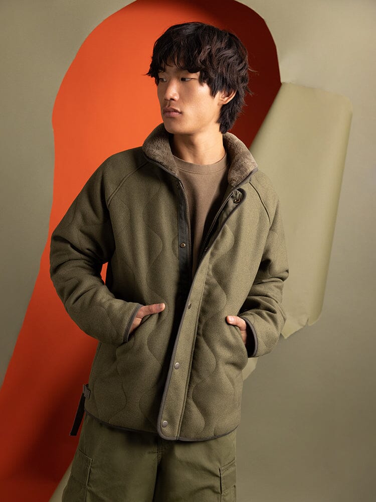 Individual sporting an Alpha Industries Wool Deck Jacket in green, coupled with cargo pants, hands in pockets.