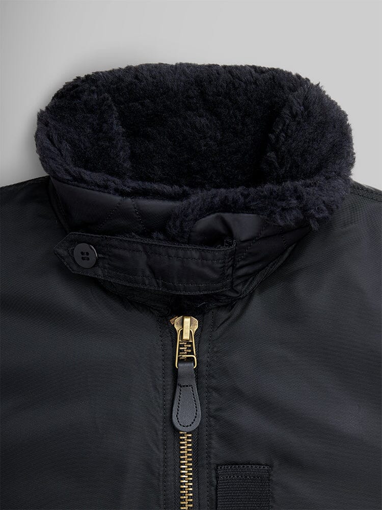Alpha Industries B-15 Mod Bomber Jacket with black zippered front, buttoned collar strap, and dark faux mouton collar lining.