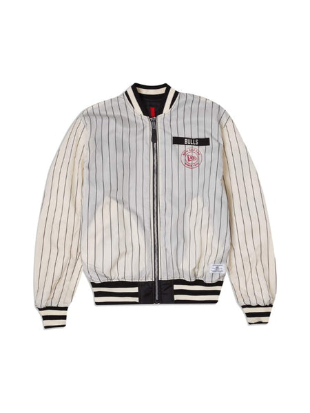 The Chicago Bulls x Alpha x New Era L-2B Bomber Jacket by Alpha Industries, featuring a white and black striped design with Bulls and a red logo on the chest, complemented by ribbed cuffs and waistband.