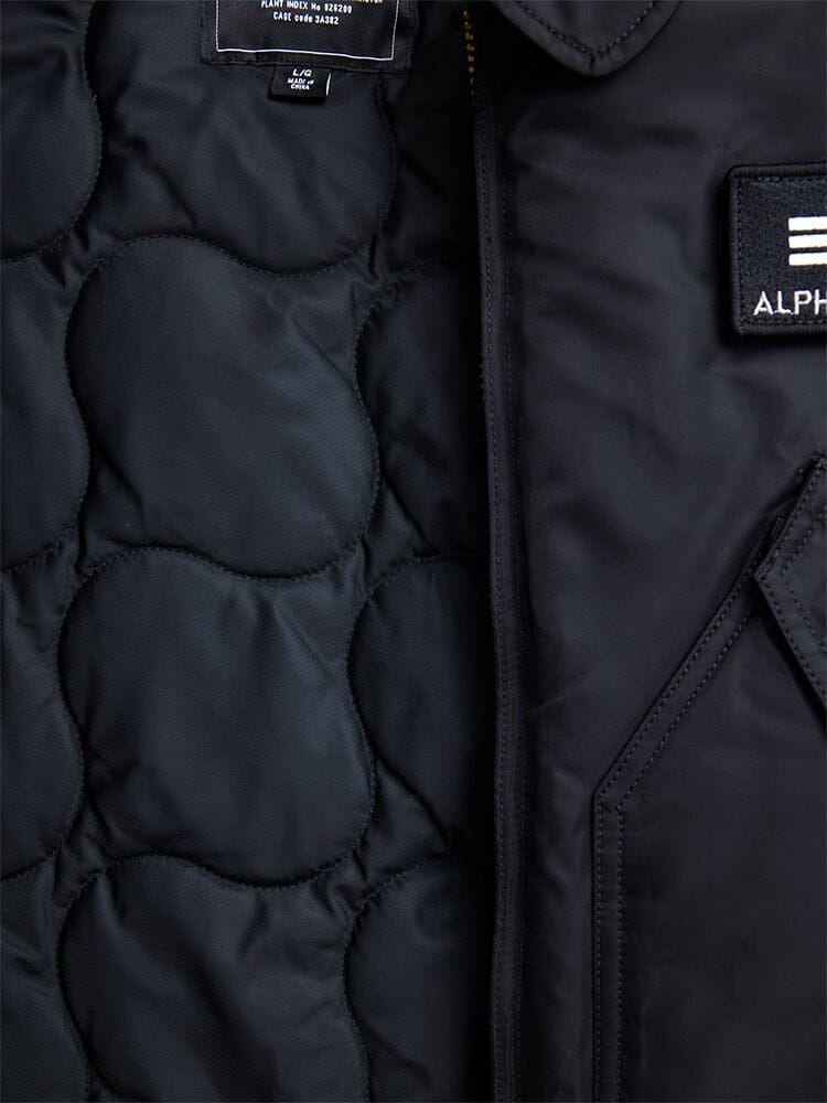 Black Cwu 45/P Bomber Jacket by Alpha Industries, showing label, stitching, and pocket with Alpha patch.