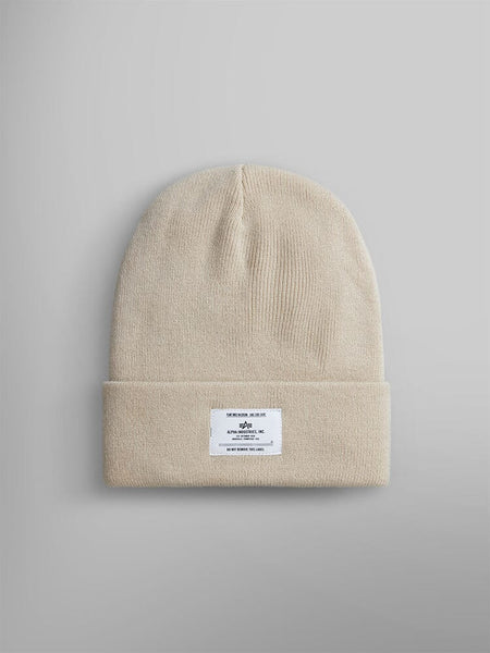 Limestone knit beanie with a folded brim and an Alpha Industries, Inc. label featuring text and a small logo.
