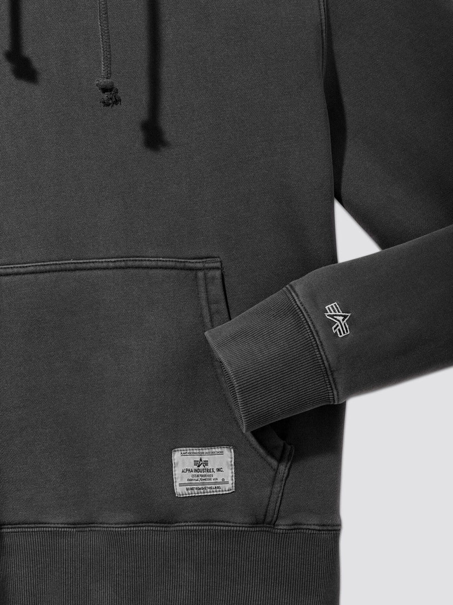 Alpha Industries Essential Washed Hoodie in dark gray featuring front pocket, visible drawstrings, small patch label, and embroidered Alpha Industries logo on sleeve.