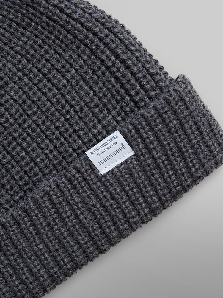 Essential Watch Cap by Alpha Industries in a wool-blend grey ribbed design with a small white label on the folded edge.