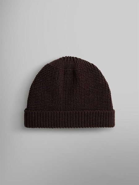The Essential Watch Cap by Alpha Industries is showcased. This cap features a folded brim and is crafted from a dark brown wool-blend material.