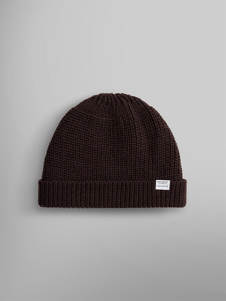 The Essential Watch Cap by Alpha Industries in the color Chocolate features a small white label and is reminiscent of a classic watch cap.