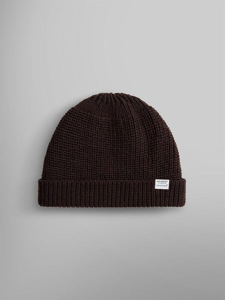 The Essential Watch Cap by Alpha Industries in the color Chocolate features a small white label and is reminiscent of a classic watch cap.