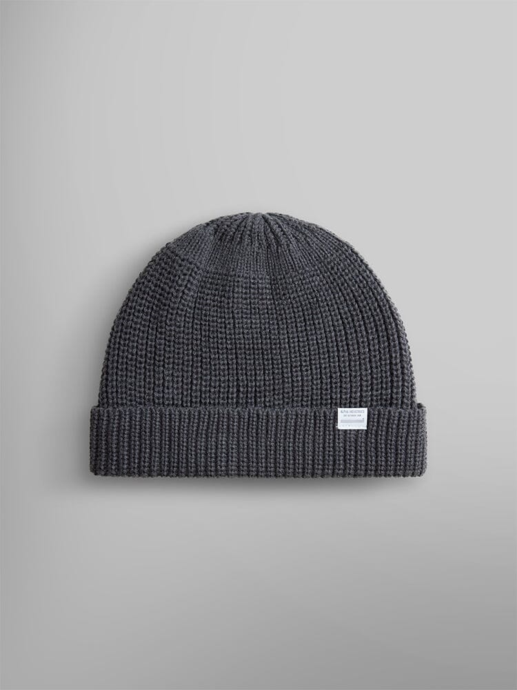 The Essential Watch Cap by Alpha Industries is a medium charcoal wool-blend knitted beanie hat with a folded brim and a small white label on the front, reminiscent of a classic watch cap.