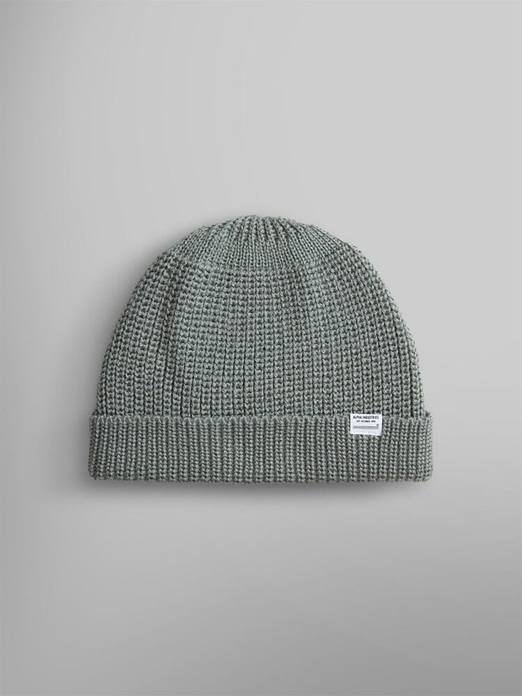 The Essential Watch Cap by Alpha Industries is a knitted seafoam watch cap made from a cozy wool-blend fabric. It features a folded brim and displays a small white label on the front.