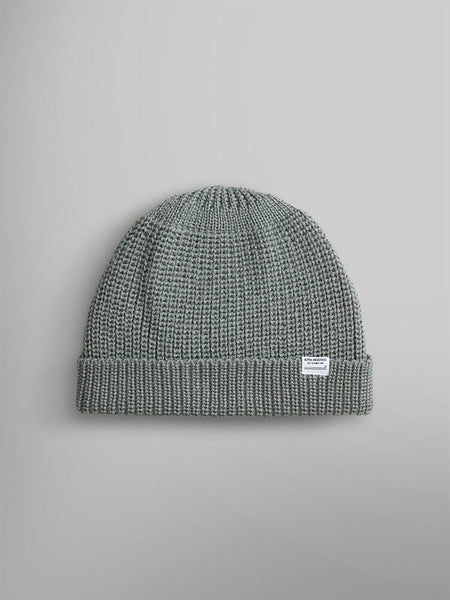 The Essential Watch Cap by Alpha Industries is a knitted seafoam watch cap made from a cozy wool-blend fabric. It features a folded brim and displays a small white label on the front.