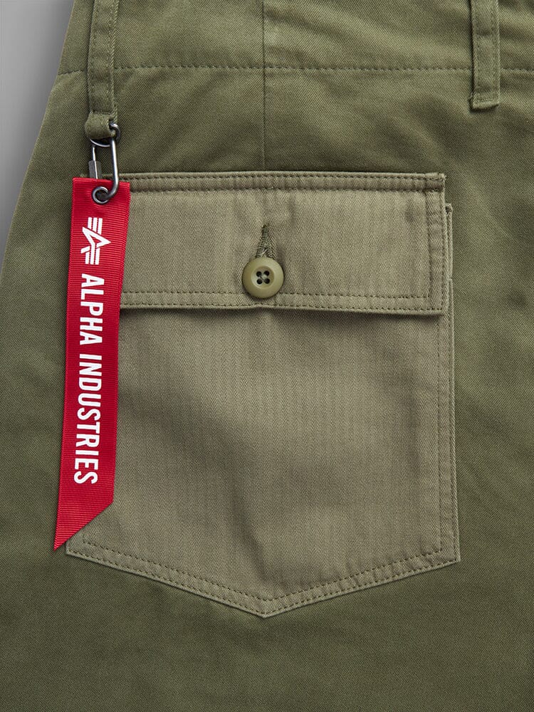 Alpha Industries Fatigue Pant, Olive Green Utility Pocket With Button, Red Tag Attached By Metal Clip.