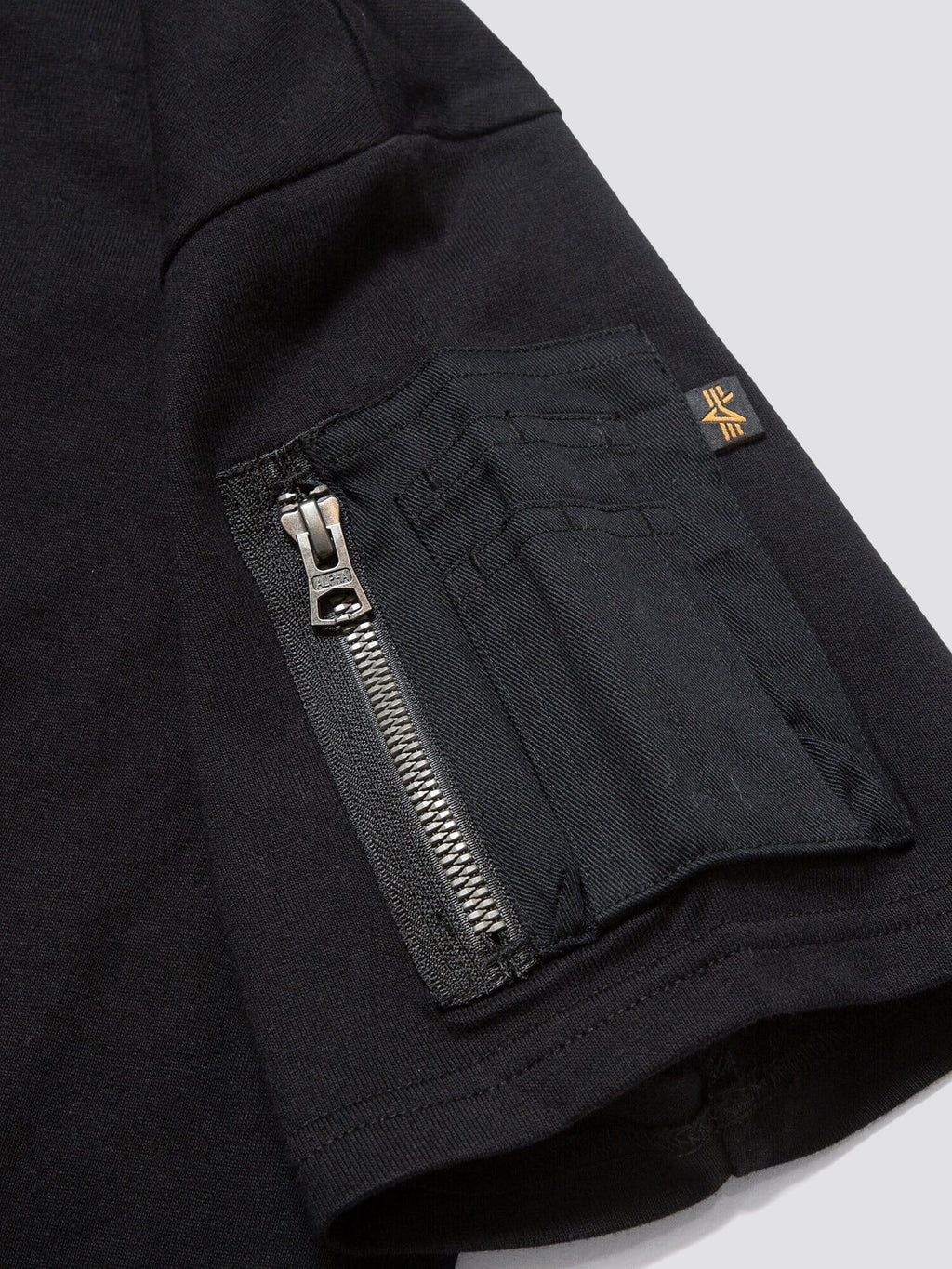 Gramicci X Alpha Cotton Cigar Pocket Tee by Alpha Industries, cotton tee with sleeve utility pocket, card slots, orange seam tag, and embroidered Gramicci logo.