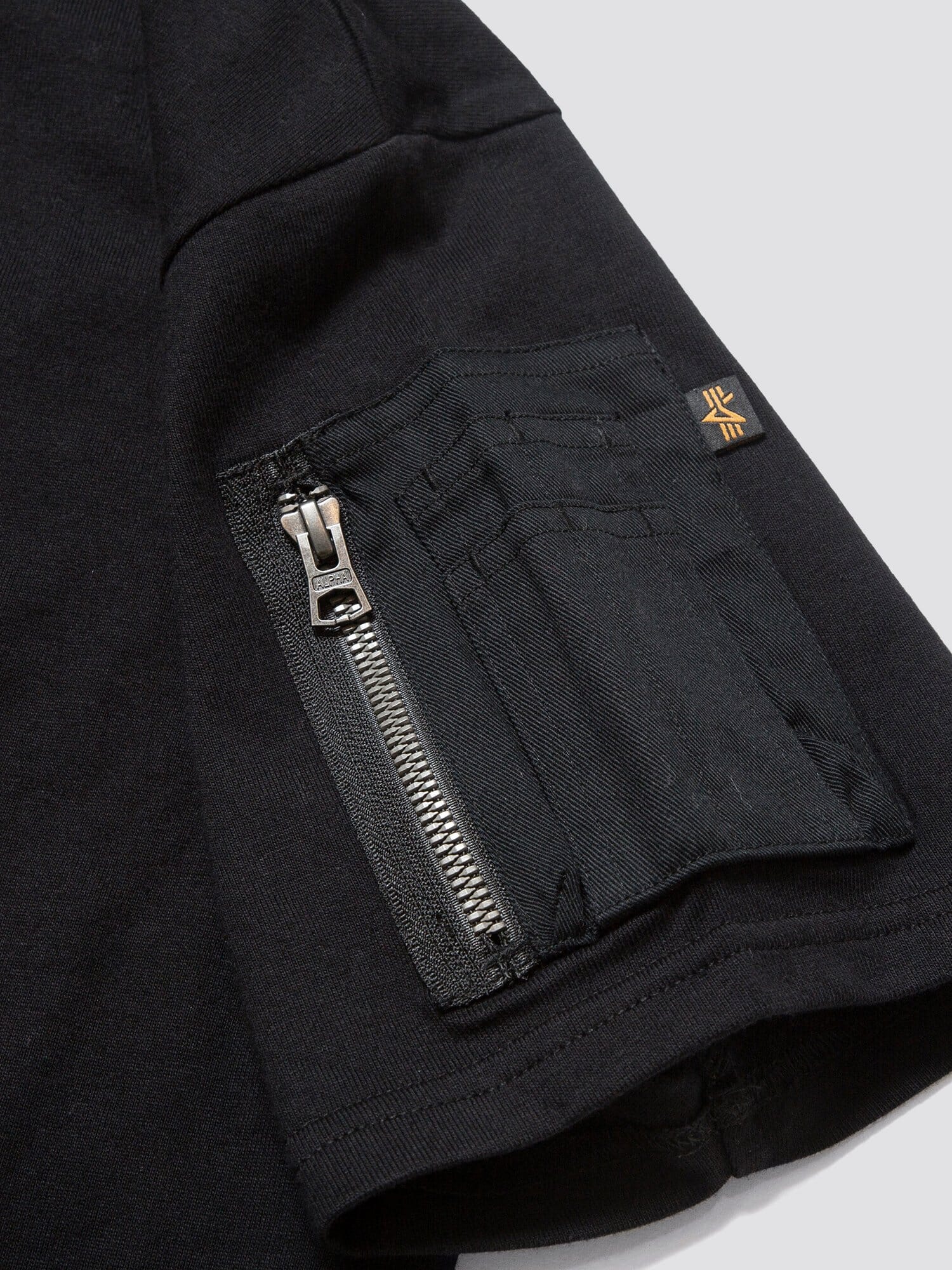 Gramicci X Alpha Cotton Cigar Pocket Tee by Alpha Industries, cotton tee with sleeve utility pocket, card slots, orange seam tag, and embroidered Gramicci logo.