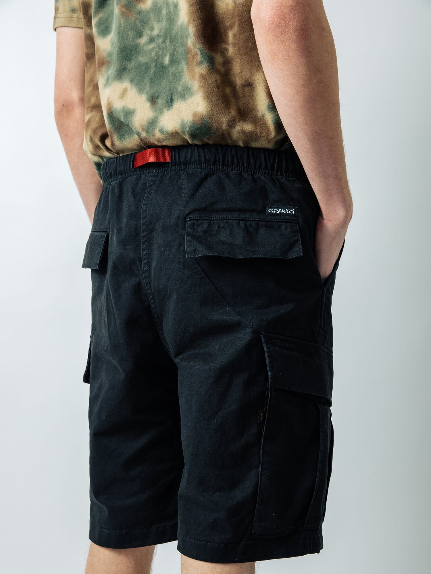 Gramicci X Alpha Jungle Cargo Short from Alpha Industries, stretch ripstop fabric, tie-dye pattern, multiple cargo pockets, red belt.