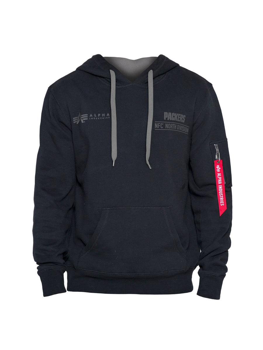 This stylish Green Bay Packers x Alpha X New Era Hoodie merges the iconic aesthetics of Alpha Industries with a sporty flair. It comes in black and features gray drawstrings, logos, and text such as Packers and Alpha Industries. A distinctive red tag on the sleeve reads "Remove Before Flight.