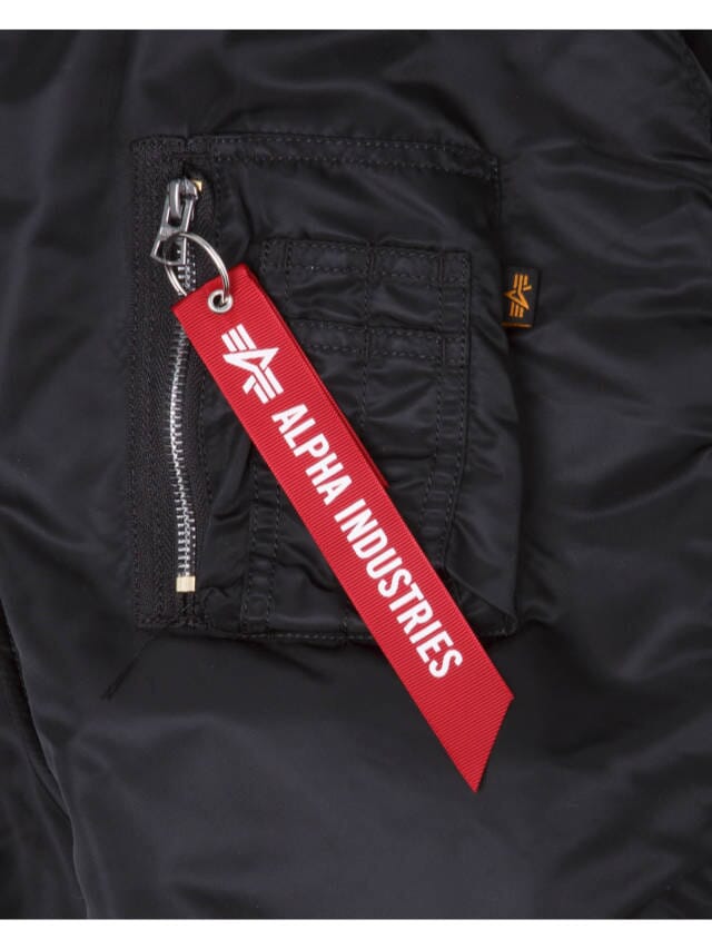 Close-up of the pocket on the Green Bay Packers x Alpha x New Era MA-1 Bomber Jacket, showcasing a silver zipper and a red fabric tag labeled with Alpha Industries / NE-NFL.