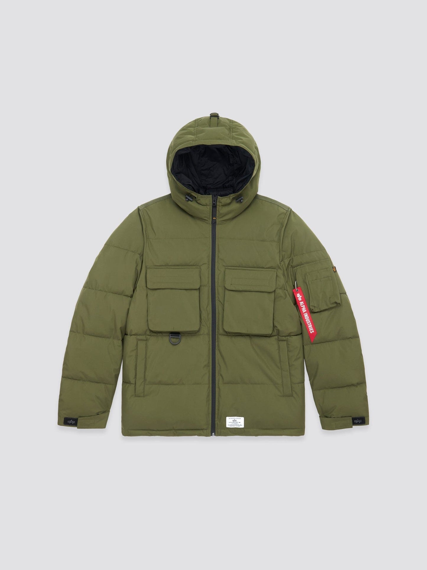 The Dark Green Hooded Puffer Jacket by Alpha Industries, Inc. includes an insulated hood, a front zipper, two spacious front pockets, and a distinctive red tag detail on the right sleeve.