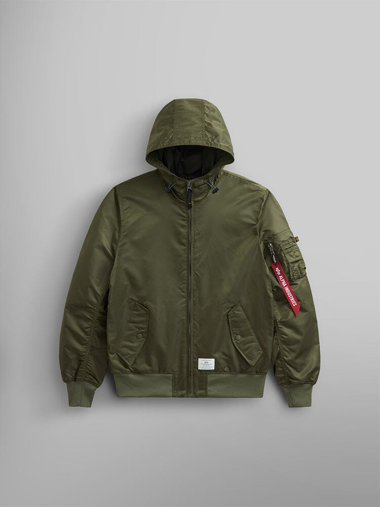 The L-2B Hooded Gen II Bomber Jacket by Alpha Industries is a water-resistant green jacket that includes a front zipper, two pockets, ribbed cuffs and hem, and features a small red tag on the sleeve.