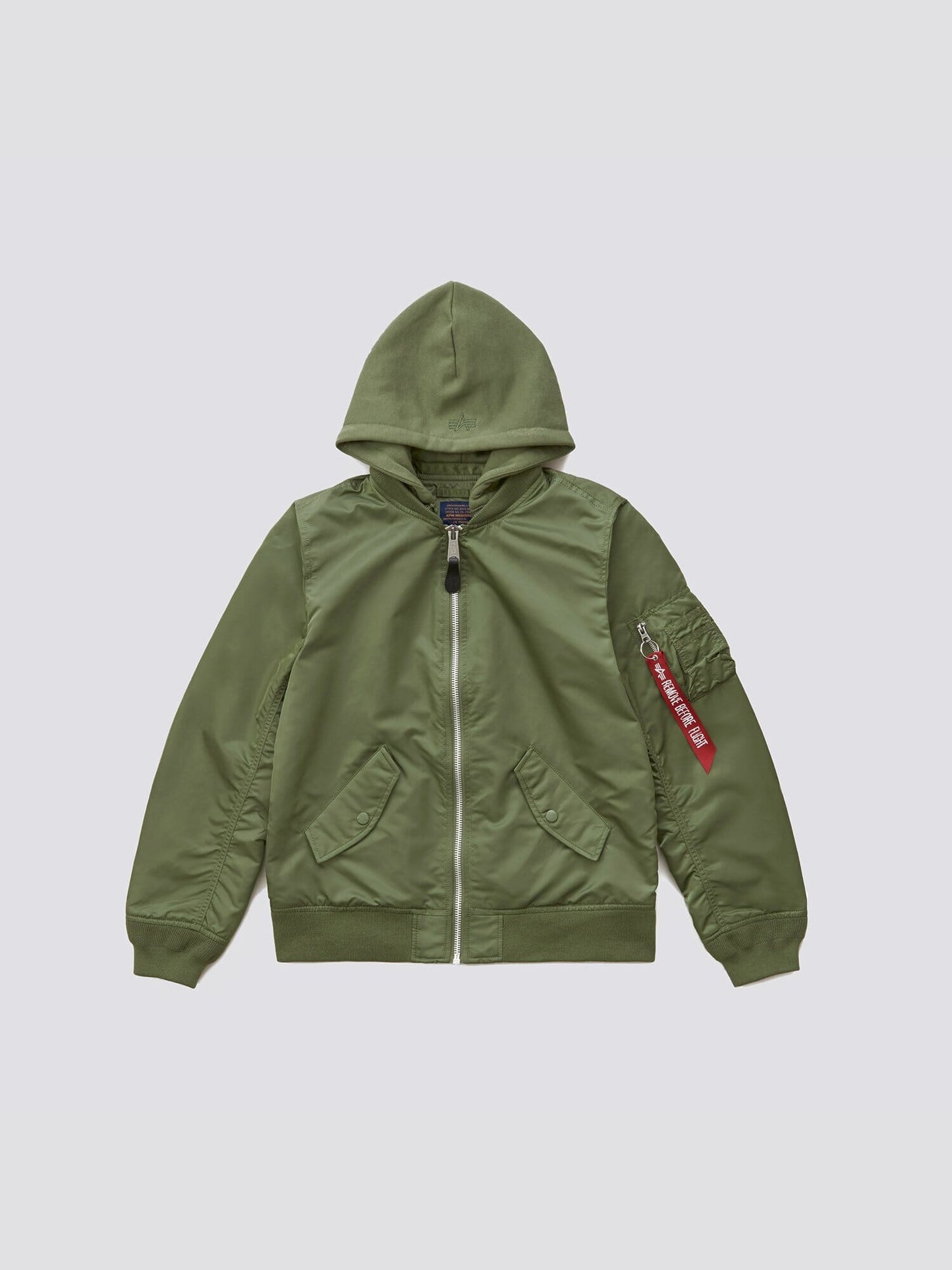 Alpha Industries L-2B Natus W Bomber Jacket in olive green with removable hood, front zipper, two front pockets, and zippered sleeve pocket with red Remove Before Flight tag.