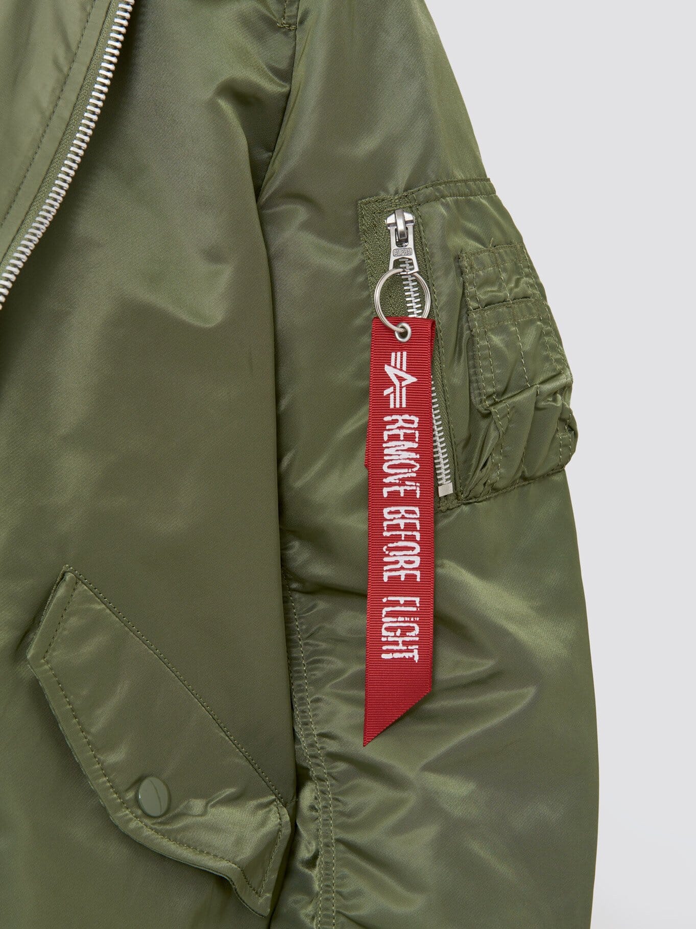 Alpha Industries L-2B Natus W Bomber Jacket, olive green, water-resistant fabric, sleeve zippered pocket, MA-1 red Remove Before Flight tag on zipper pull.