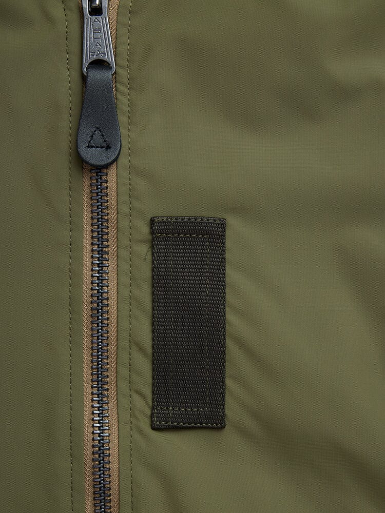 Alpha Industries L-2B Skymaster Gen II Bomber Jacket, olive green fabric, black zipper, black rectangular oxygen tab detail.