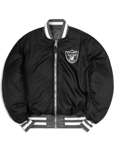 The Las Vegas Raiders X Alpha x New Era MA-1 Bomber Jacket by Alpha Industries and NE-NFL features a Raiders logo on the chest, gray and white striped cuffs and collar, a front zipper, and NFL team patches. This stylish bomber jacket is also water-resistant, making it perfect for any weather.