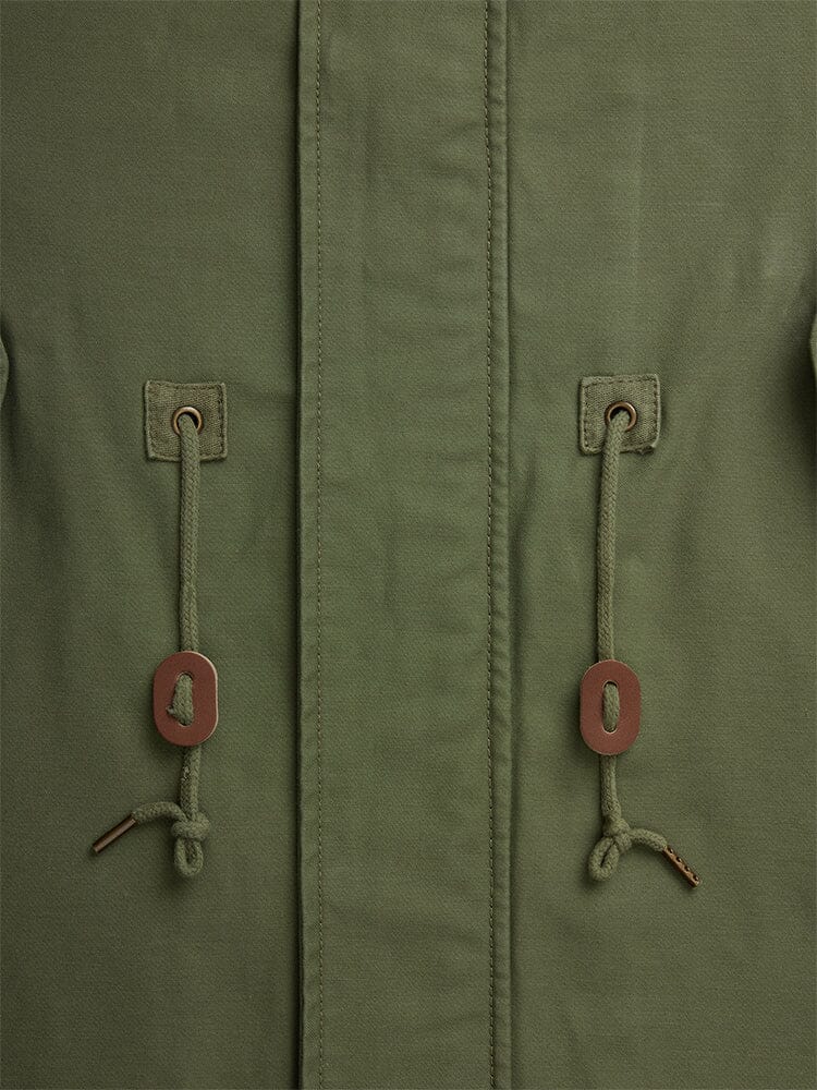Alpha Industries M-59 Fishtail Mod Parka in olive green with two drawstrings, brown metal grommets, rectangular tabs, and central seam.