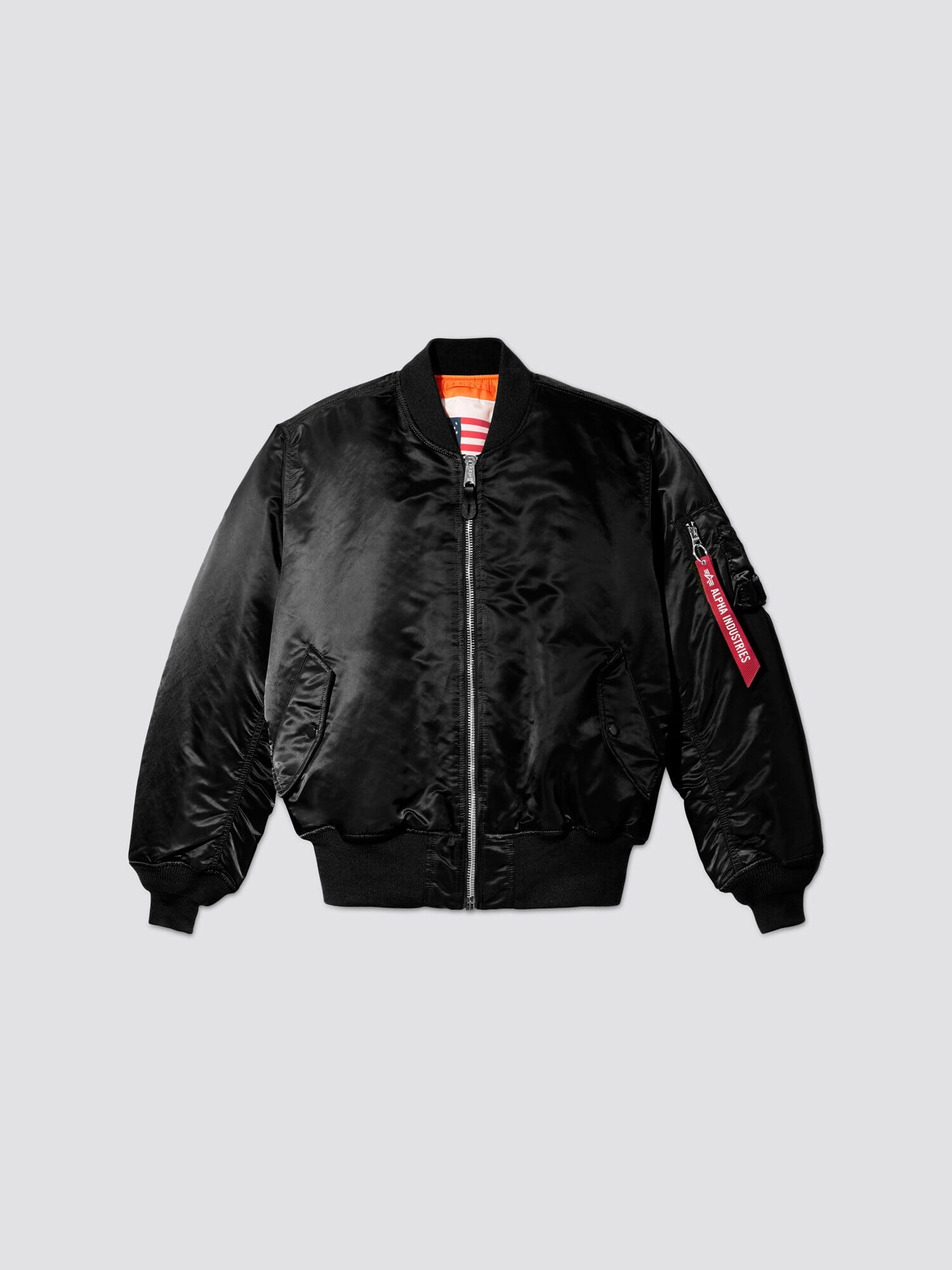 Alpha Industries MA-1 Blood Chit: black flight jacket, front zipper, ribbed cuffs and hem, two front pockets, sleeve zip pocket with red tag.