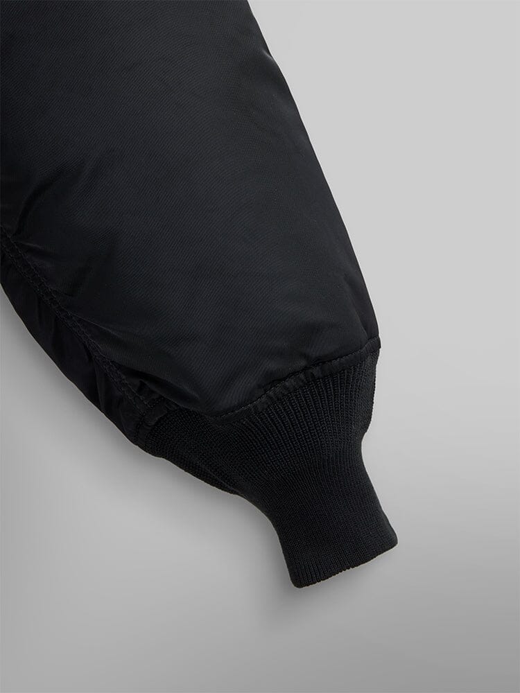 Close up view of MA-1 Bomber Jacket (Heritage) in Black. Sleeve and ribbed cuff. By Alpha Industries.