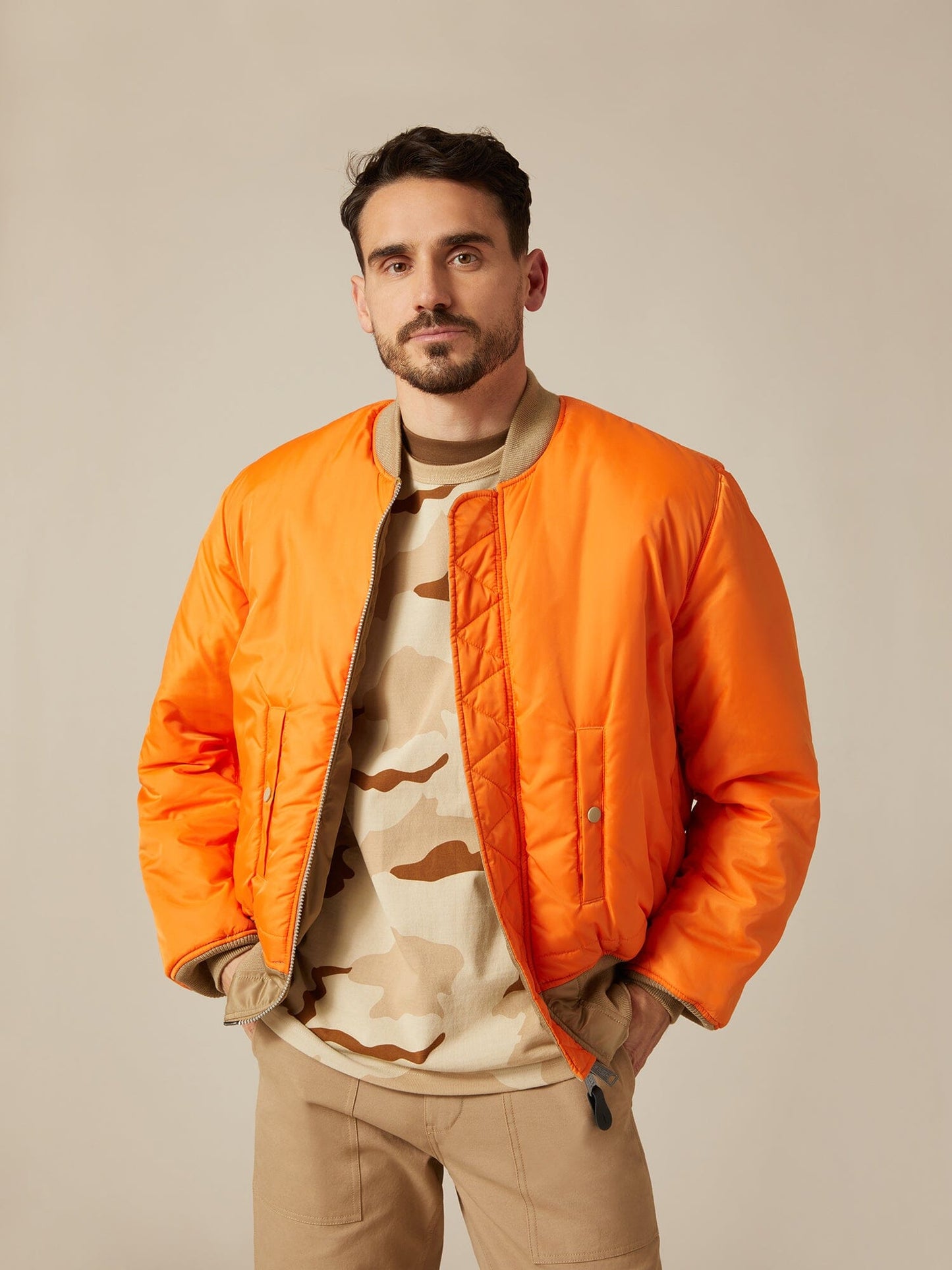 Front view of MA-1 Bomber Jacket (Heritage) in Khaki (Vintage) with male model. Reversed view (Orange). By Alpha Industries.