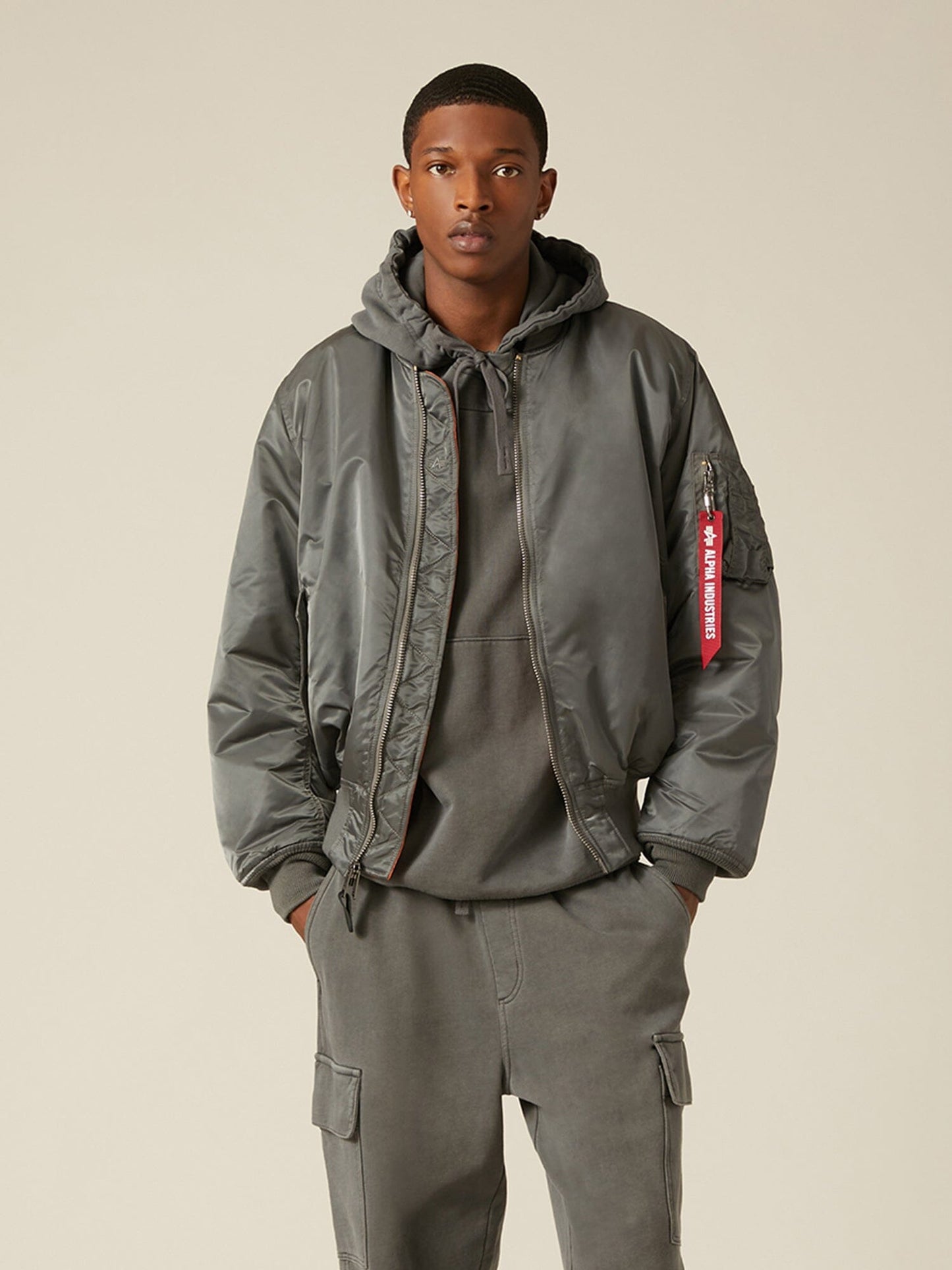 Front view of MA-1 Bomber Jacket (Heritage) in Sliver (Gunmetal) with male model. Knees up view. By Alpha Industries.