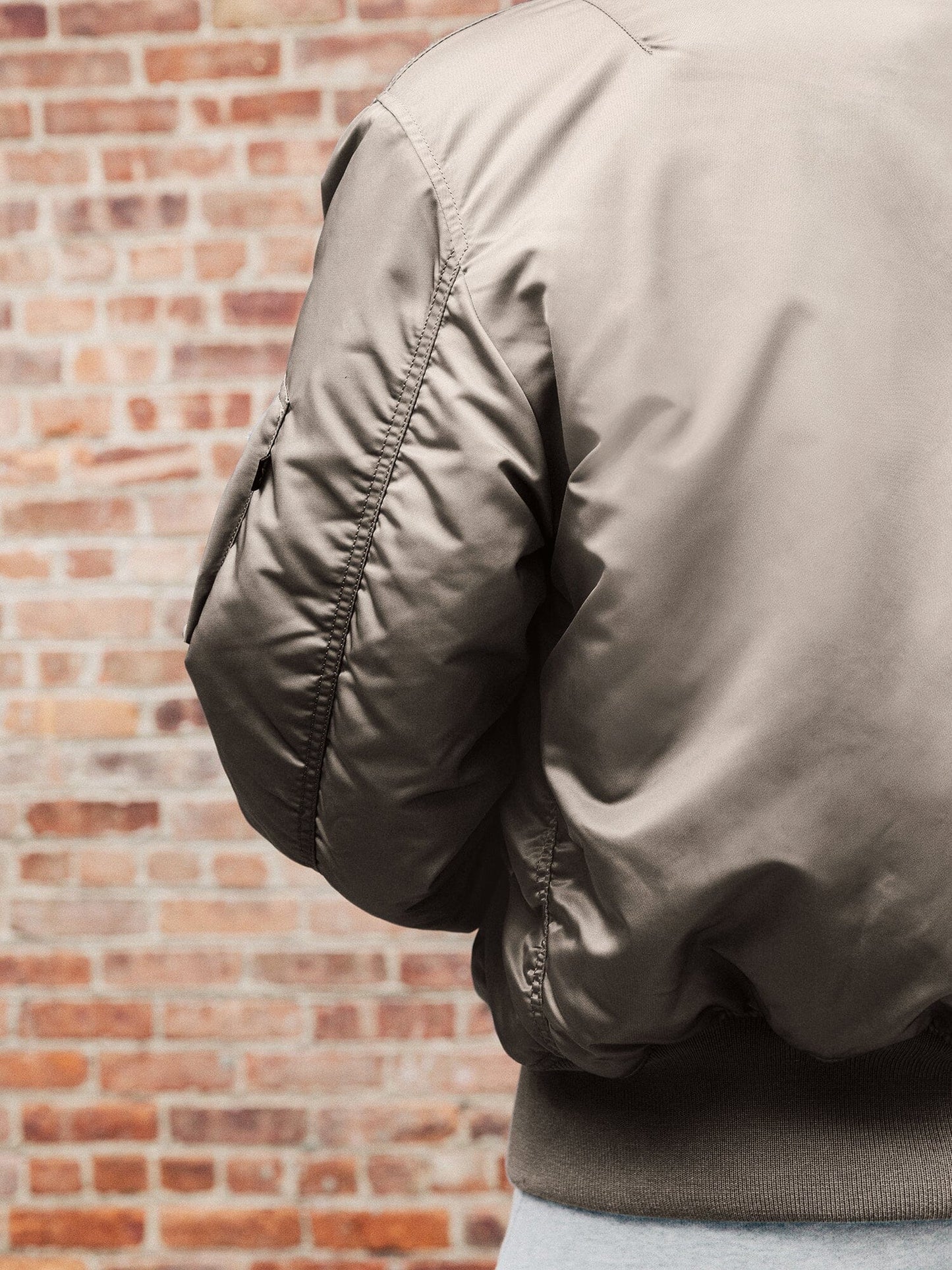 Back view of MA-1 Bomber Jacket (Heritage) in Gray with male model. Sleeve stiching. By Alpha Industries.